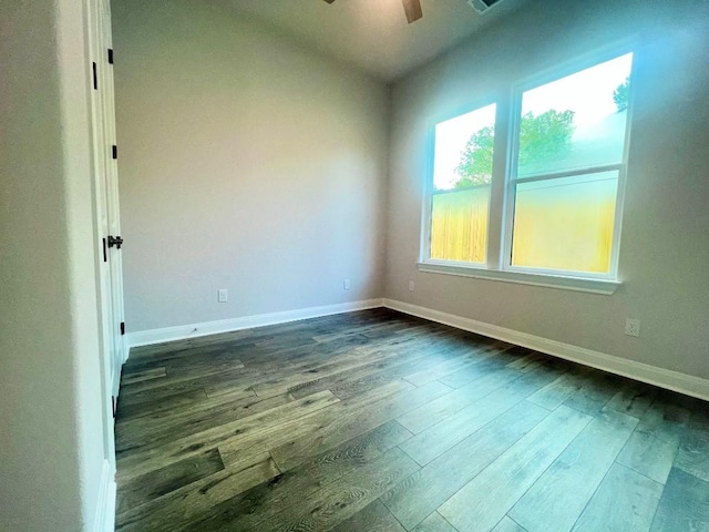 unfurnished room with dark wood-style floors, ceiling fan, and baseboards