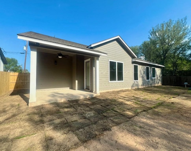 rear view of house with fence, a ceiling fan, and a patio