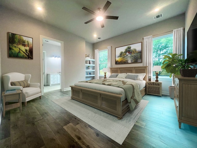 bedroom featuring ceiling fan, ensuite bath, and hardwood / wood-style floors