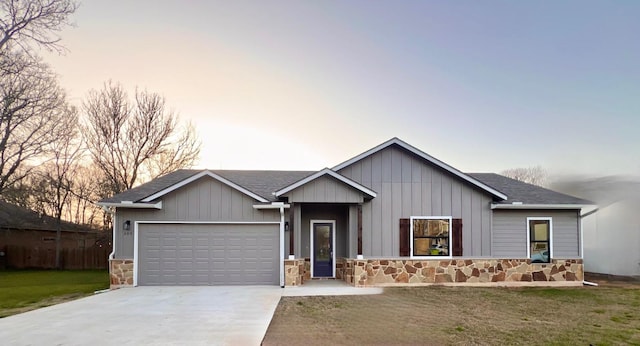 view of front of property featuring board and batten siding, a garage, stone siding, driveway, and a front lawn