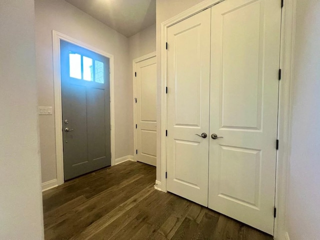 foyer with dark wood-style floors and baseboards