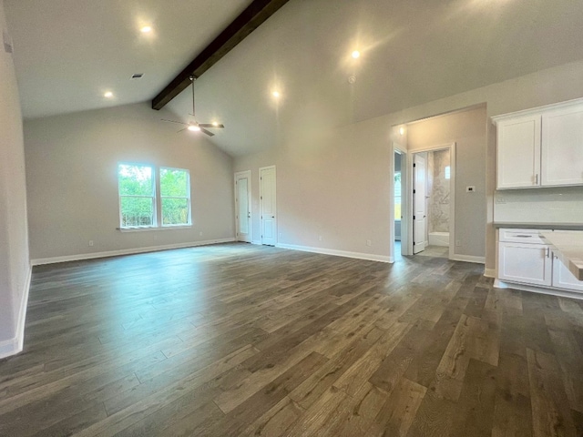 unfurnished living room featuring beam ceiling, dark hardwood / wood-style floors, and ceiling fan