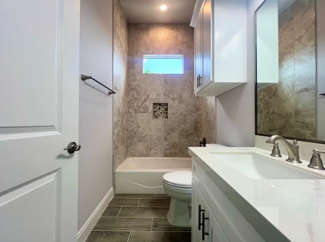 full bathroom with tiled shower / bath, vanity, and toilet