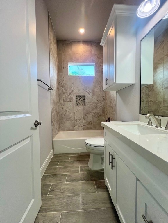 full bathroom with tiled shower / bath, vanity, and toilet