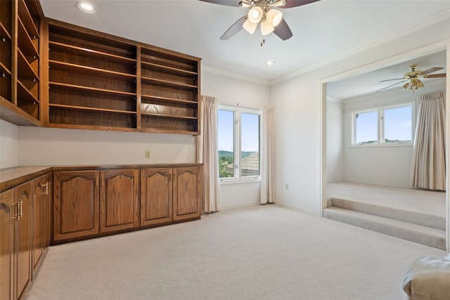 carpeted living room with crown molding and ceiling fan