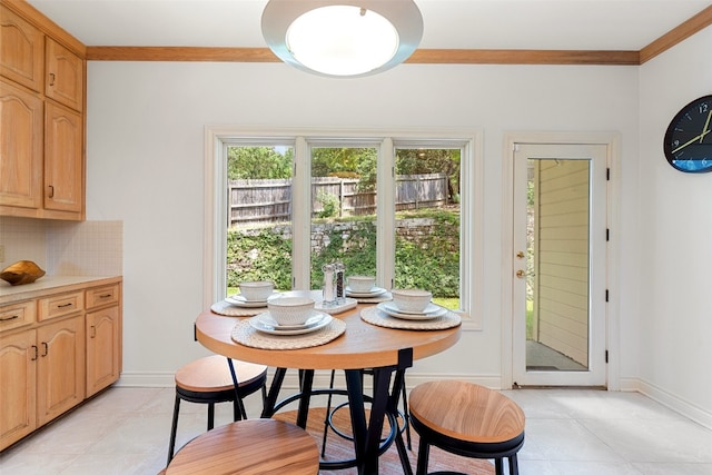 tiled dining room featuring crown molding