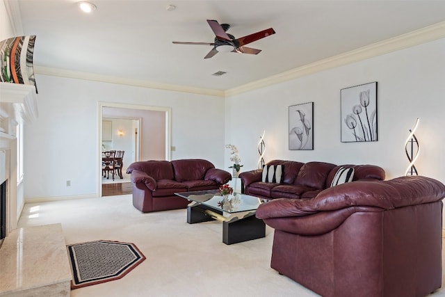 living room with a fireplace, crown molding, ceiling fan, and carpet floors