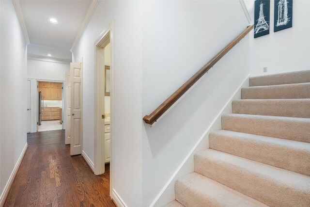 staircase with crown molding and hardwood / wood-style flooring