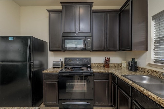 kitchen featuring dark brown cabinets, light tile patterned flooring, light stone countertops, black appliances, and sink