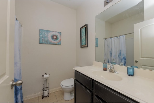 bathroom with toilet, vanity, and tile patterned flooring