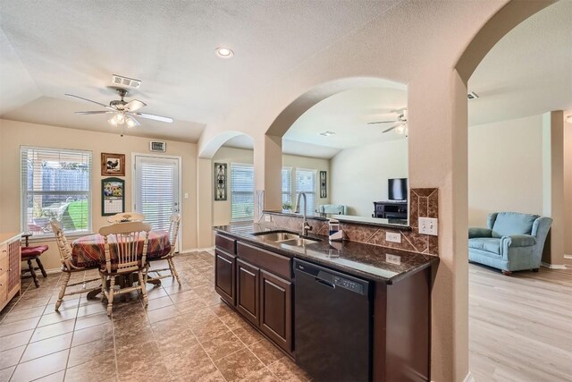 kitchen featuring decorative backsplash, dark brown cabinets, dishwasher, vaulted ceiling, and sink