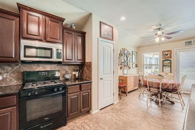 kitchen featuring ceiling fan, decorative backsplash, black gas range oven, dark brown cabinets, and vaulted ceiling