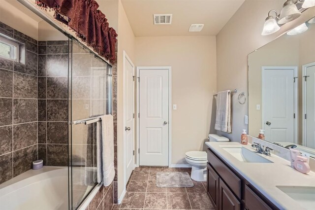 full bathroom with toilet, bath / shower combo with glass door, and vanity