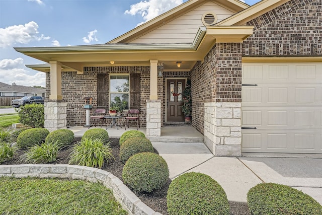 view of exterior entry featuring a porch and a garage