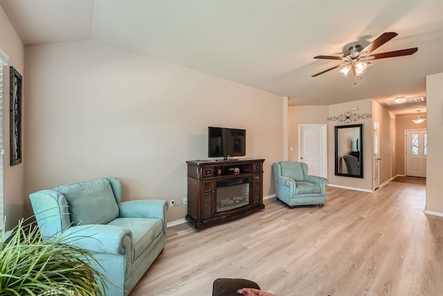 living room featuring light hardwood / wood-style floors, ceiling fan, and vaulted ceiling