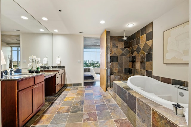 bathroom featuring vanity, independent shower and bath, and a wealth of natural light