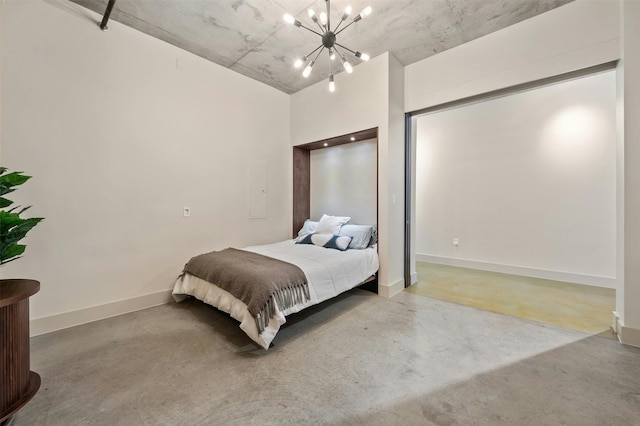 bedroom featuring a notable chandelier and concrete floors