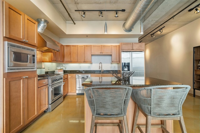 kitchen with sink, a kitchen breakfast bar, a kitchen island, stainless steel appliances, and a high ceiling