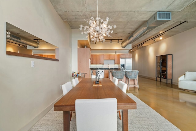 dining space featuring an inviting chandelier, track lighting, and sink