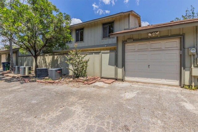 view of front of property with central air condition unit, driveway, and an attached garage