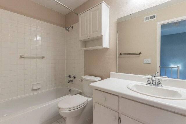 bathroom featuring visible vents, toilet, shower / bathtub combination, vanity, and a textured wall