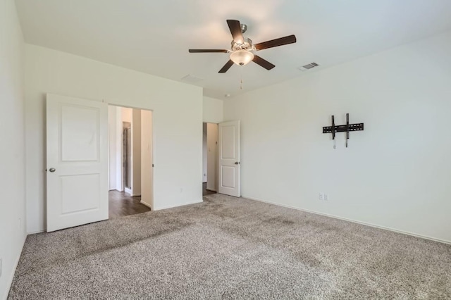 unfurnished bedroom featuring dark carpet and ceiling fan