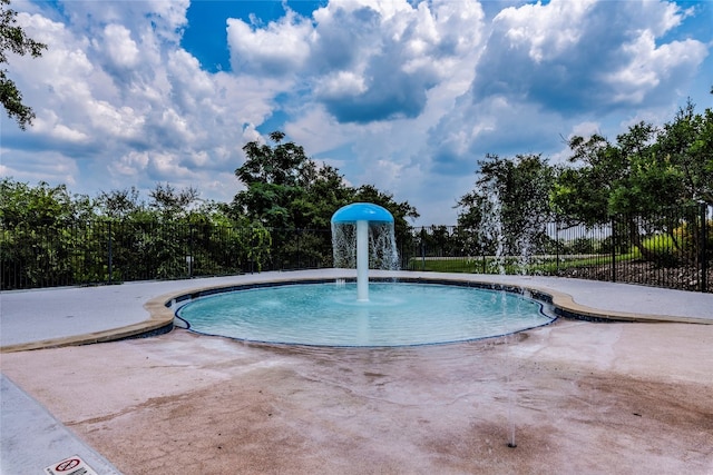 view of swimming pool with pool water feature and a patio area