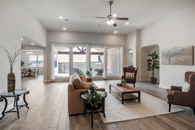 living room with ceiling fan with notable chandelier