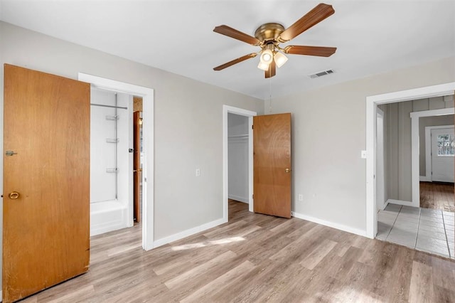 unfurnished bedroom featuring connected bathroom, light hardwood / wood-style flooring, and ceiling fan