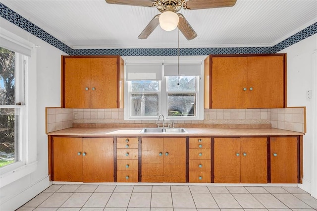 kitchen with decorative backsplash, a wealth of natural light, sink, and ceiling fan