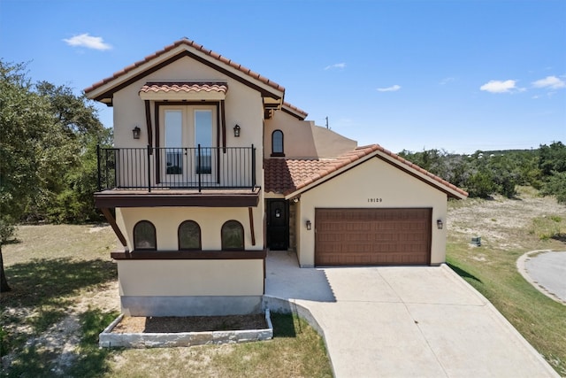 mediterranean / spanish-style house with a balcony, a garage, and a front yard