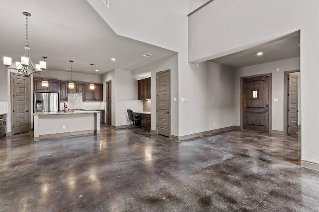 unfurnished living room featuring a chandelier