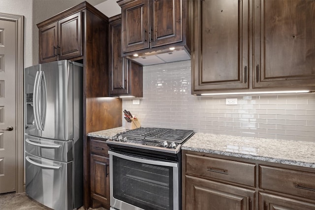 kitchen with appliances with stainless steel finishes, tasteful backsplash, and light stone countertops