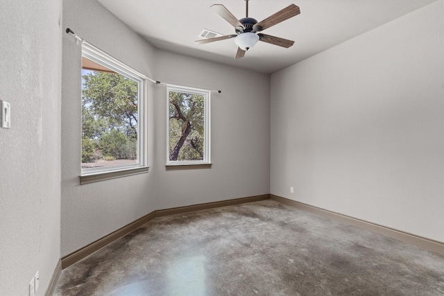 unfurnished room with ceiling fan and concrete flooring