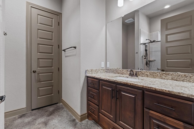 bathroom featuring tiled shower and vanity