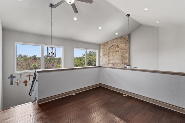 interior space featuring hardwood / wood-style floors, ceiling fan with notable chandelier, and vaulted ceiling