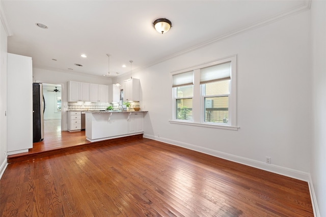 unfurnished living room featuring crown molding and hardwood / wood-style flooring