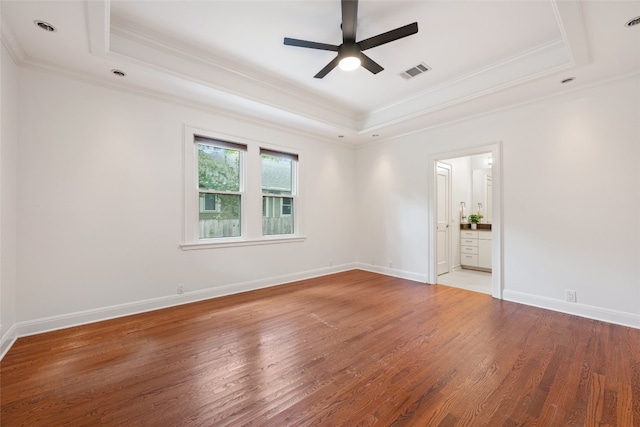 unfurnished room with ceiling fan, a tray ceiling, and wood-type flooring