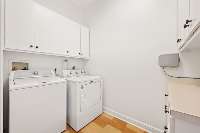 clothes washing area with independent washer and dryer, light tile patterned flooring, and cabinets