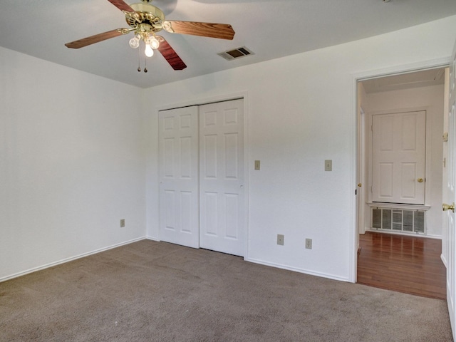 unfurnished bedroom featuring a ceiling fan, visible vents, dark carpet, and a closet