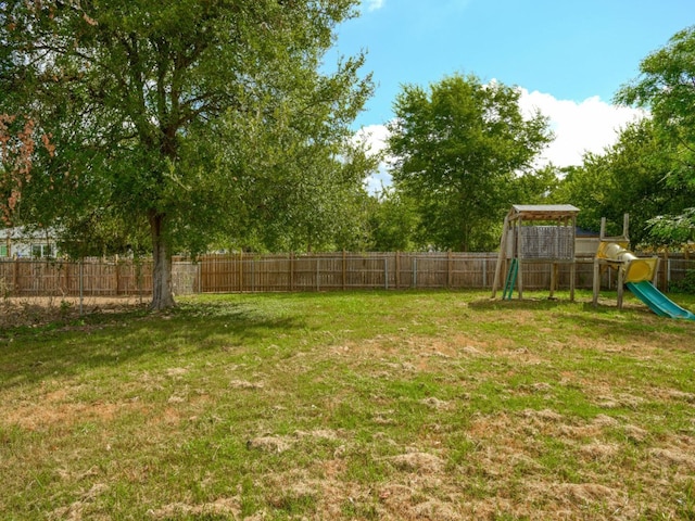 view of yard featuring a playground and a fenced backyard