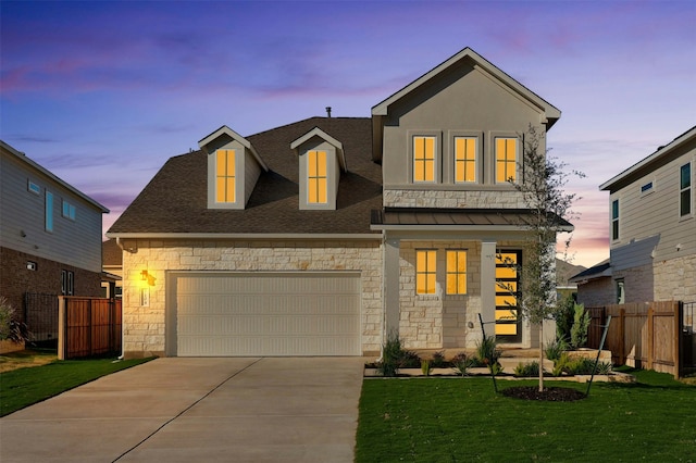 view of front of home with a garage and a lawn