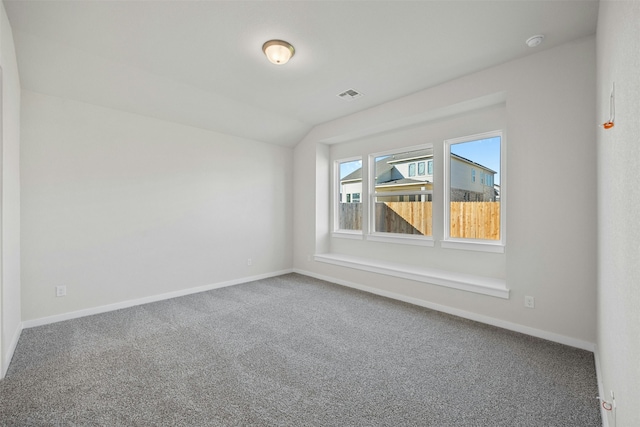 unfurnished room with lofted ceiling and carpet floors