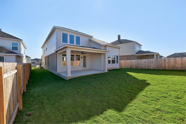 back of house with ceiling fan, a patio, and a lawn