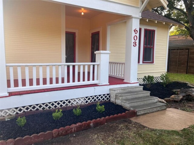 view of exterior entry featuring covered porch