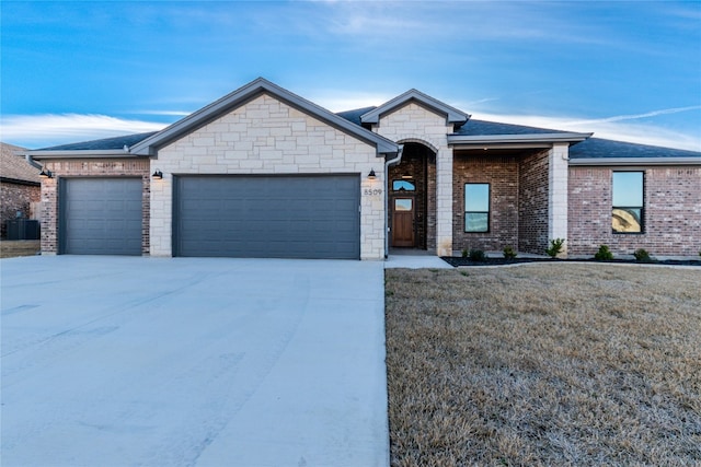 single story home featuring a front lawn and a garage