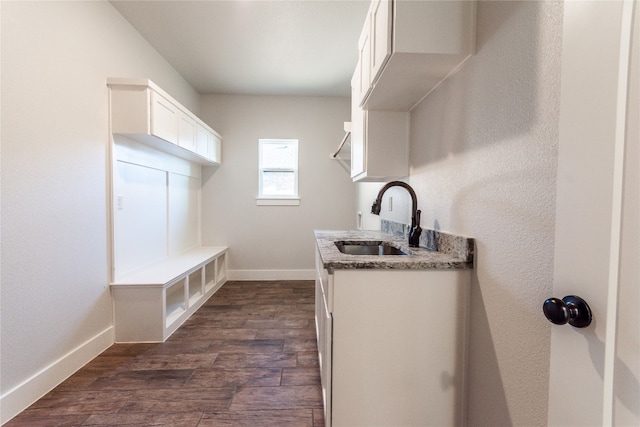 kitchen featuring white cabinets, sink, dark hardwood / wood-style flooring, and light stone counters