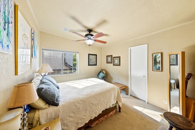 bedroom featuring light carpet, vaulted ceiling, and ceiling fan