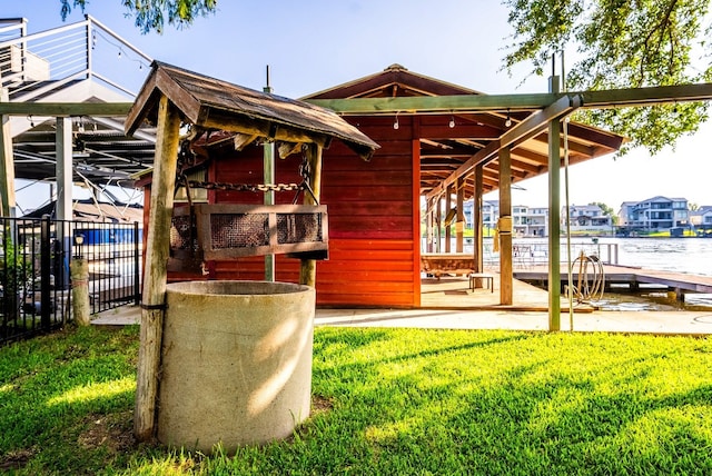 rear view of property featuring a lawn and a water view