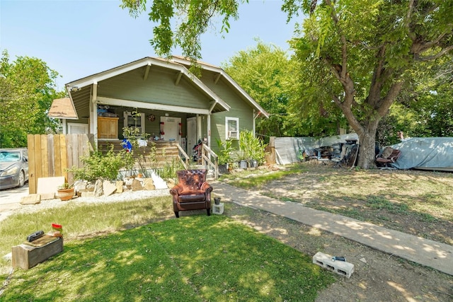 view of front of property featuring covered porch and a front lawn